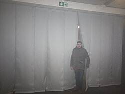 Person geht durch eine passierbare Rauchschürze aus Gewebestreifen