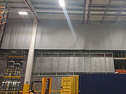 Textil-Starre Rauchschürze mit Durchführungen für Leitungen in einer Industriehalle