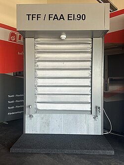 Trade fair model of the TFF-EI-ALL fire curtain as conveyor system closure FAA EI 90