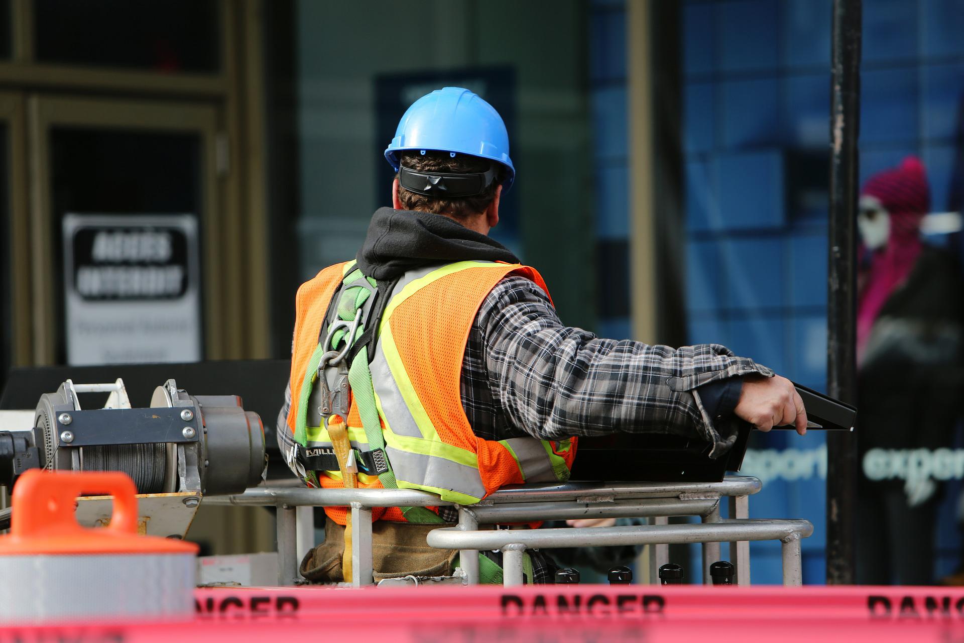 Installer with helmet and safety vest working on a lifting platform
